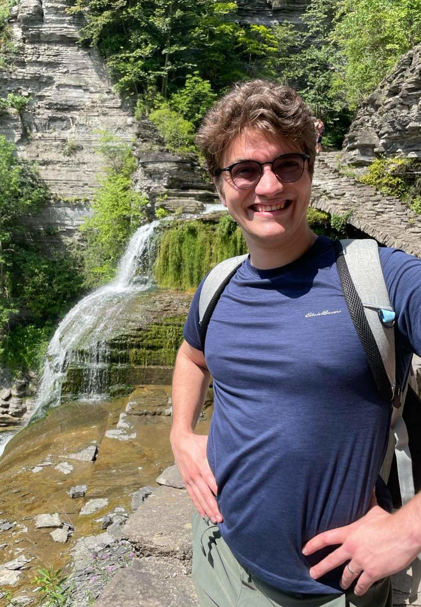 Sam standing in front of a waterfall
